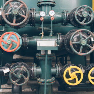 Válvula solenoide industrial com sinais visíveis de desgaste em sistema de tubulação